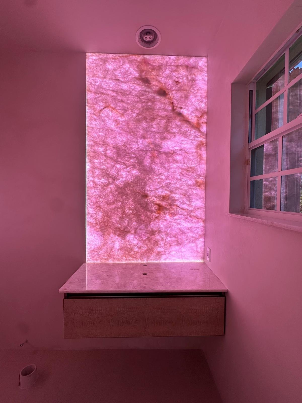 Backlit rose quartz full-height feature wall