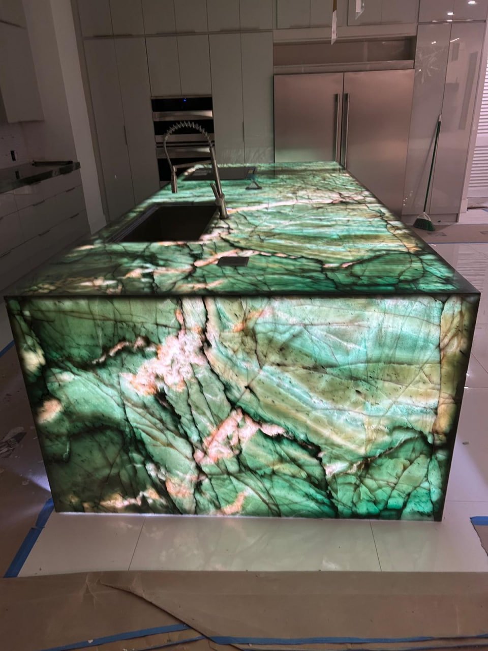 Backlit green quartzite waterfall island — daytime
